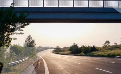 A highway passing under an overpass at sunset